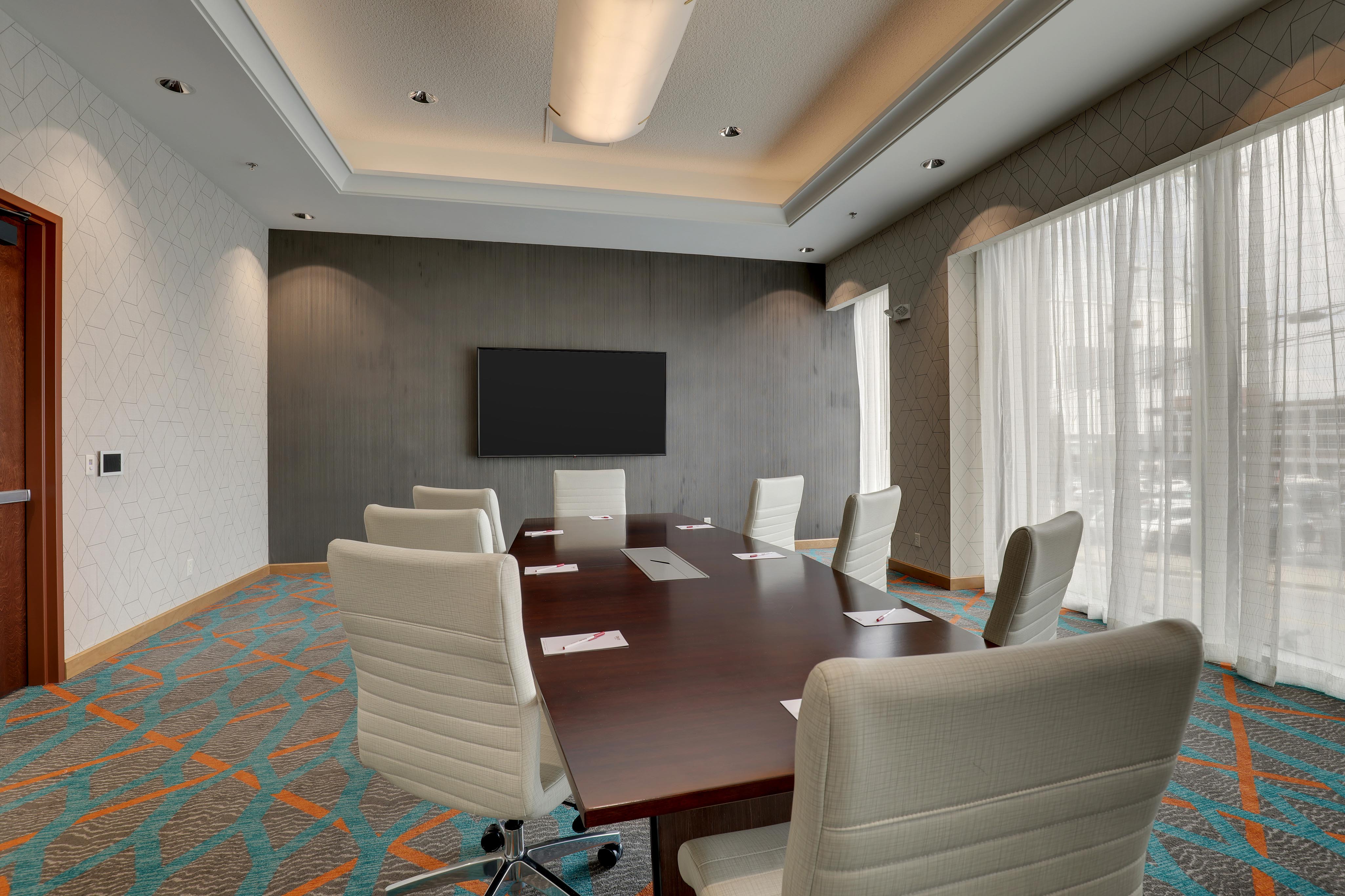 Large meeting room with two large projector screens, view from back