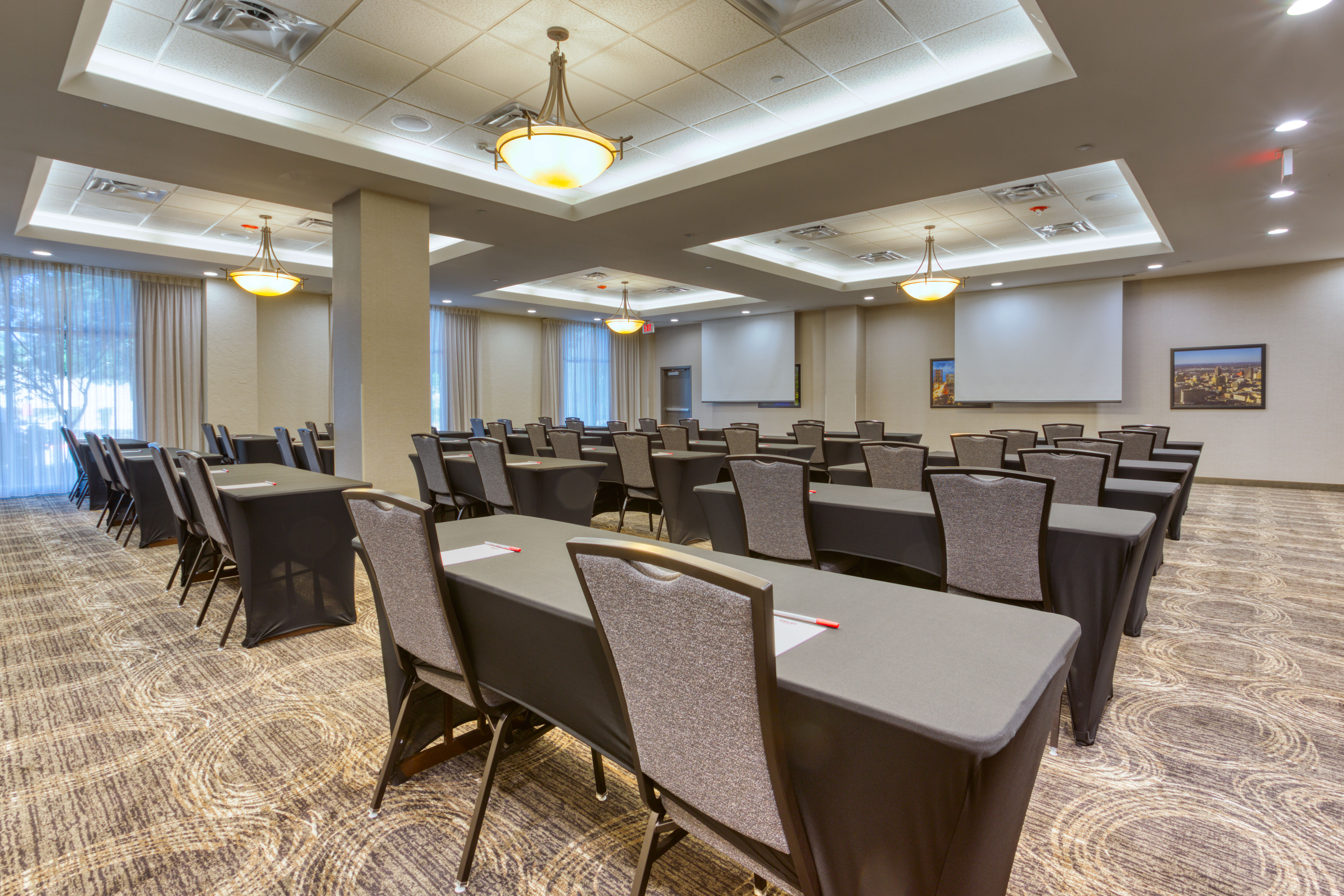 Large meeting room with two large projector screens, view from back